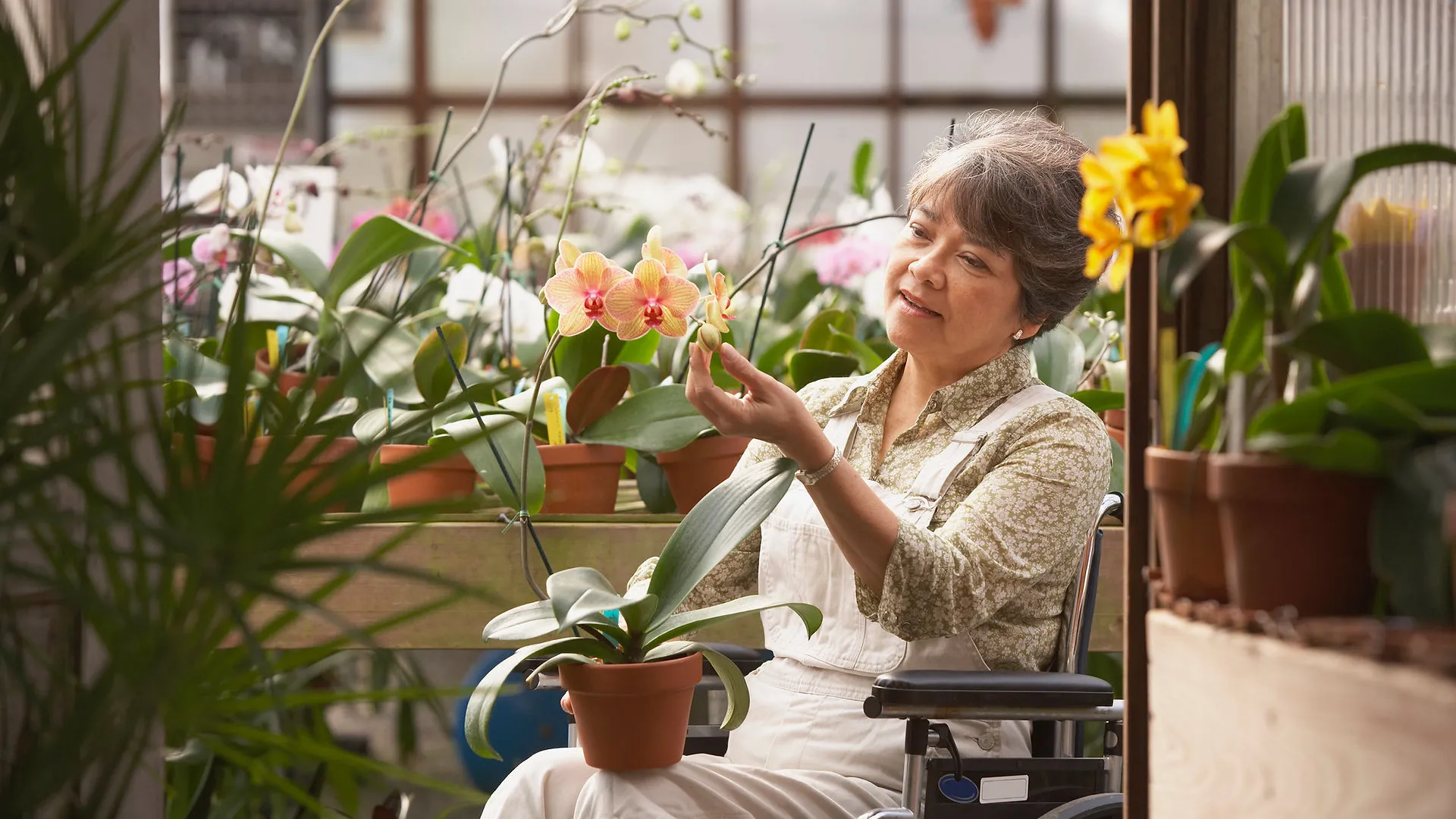 Woman enjoying a calm moment in a greenhouse